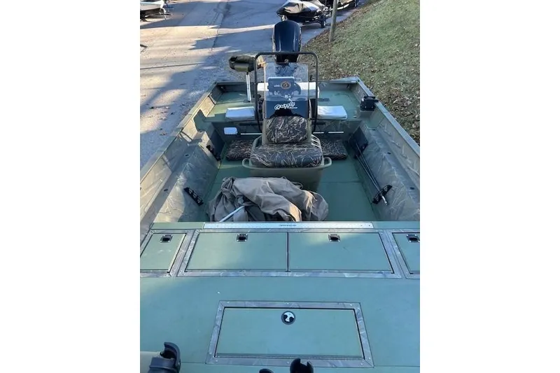 Slide: The Image of 2016 Tracker Grizzly 2072 MVX CC boat interior with storage compartments and camouflage seat. - 3