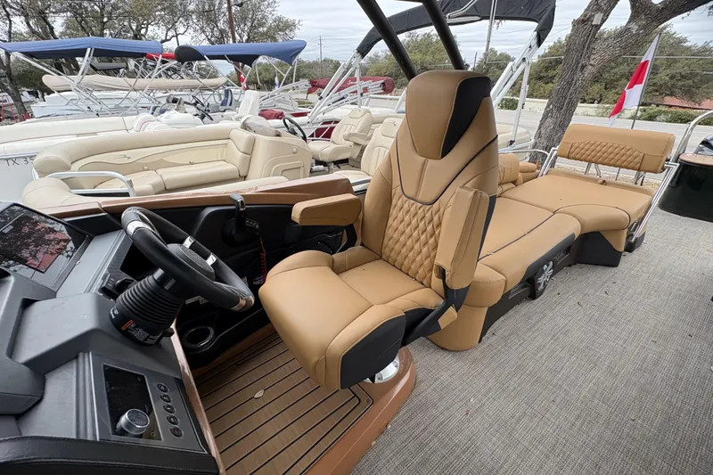 Slide: The Image of 2025 Avalon Excalibur LTD Quad Lounge boat interior with luxurious seating and modern dashboard. - 12