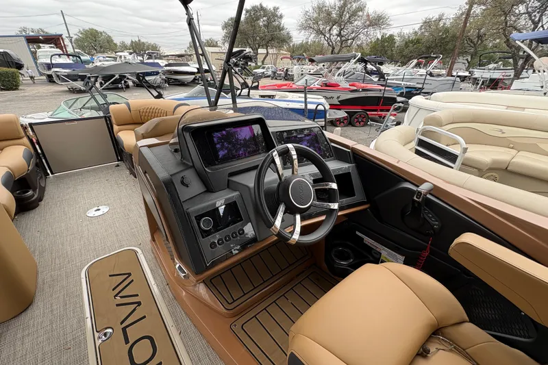 Slide: The Image of 2025 Avalon Excalibur LTD Quad Lounge boat interior with modern dashboard and luxurious seating. - 8