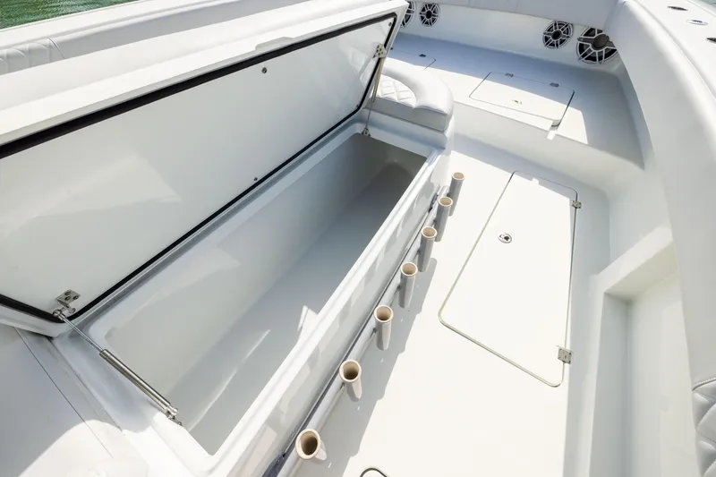 Slide: The Image of Open storage compartment on 2022 Freeman 42LR boat deck with rod holders. - 13