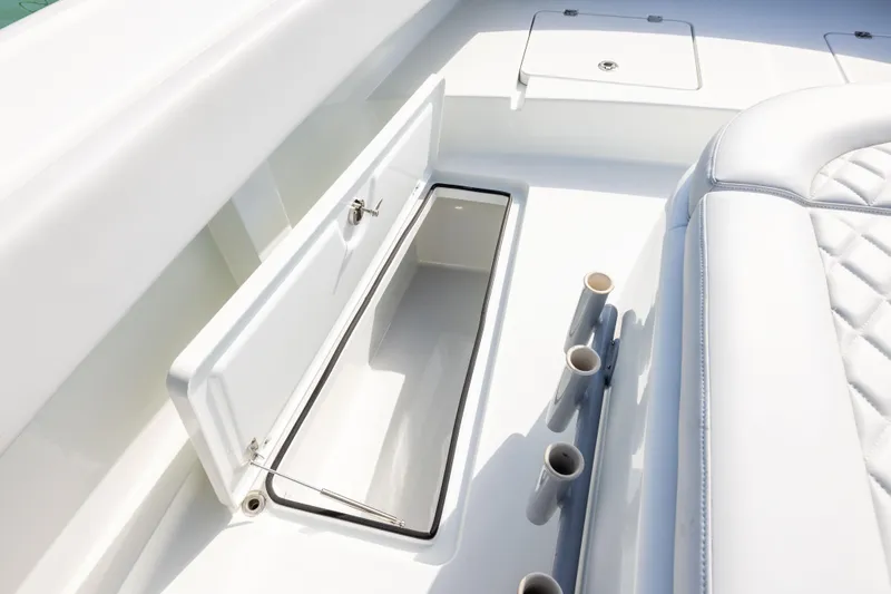 Slide: The Image of 2022 Freeman 42LR boat interior with open storage compartment and rod holders. - 33