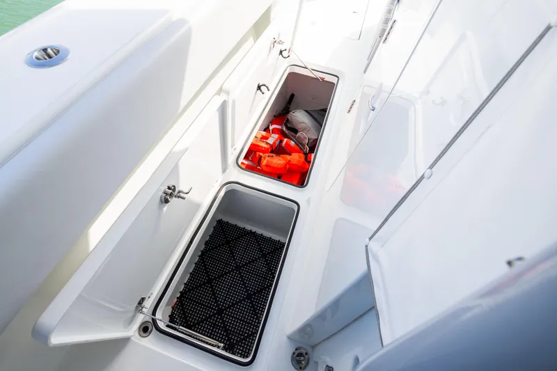 Slide: The Image of Storage compartments on a 2022 Freeman 42LR boat, containing life jackets and equipment. - 34