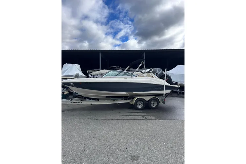 Slide: The Image of 2020 Regal 21 OBX boat on trailer under cloudy sky. - 2