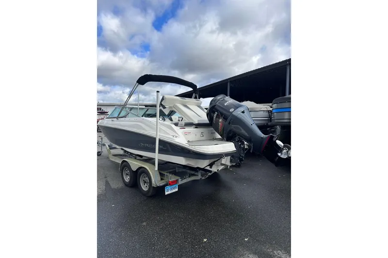 Slide: The Image of 2020 Regal 21 OBX boat on trailer, parked outdoors under cloudy sky. - 4