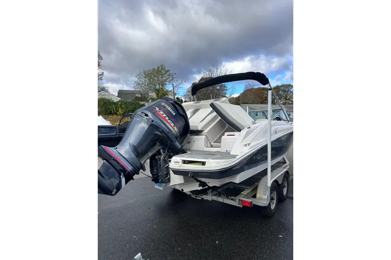 Slide: The Image of 2020 Regal 21 OBX boat with Yamaha outboard motor on trailer, parked outdoors. - 6