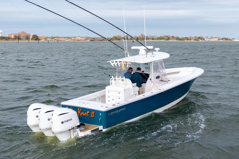 Slide: The Image of 2018 Regulator 34SS boat on water with two people aboard. - 34