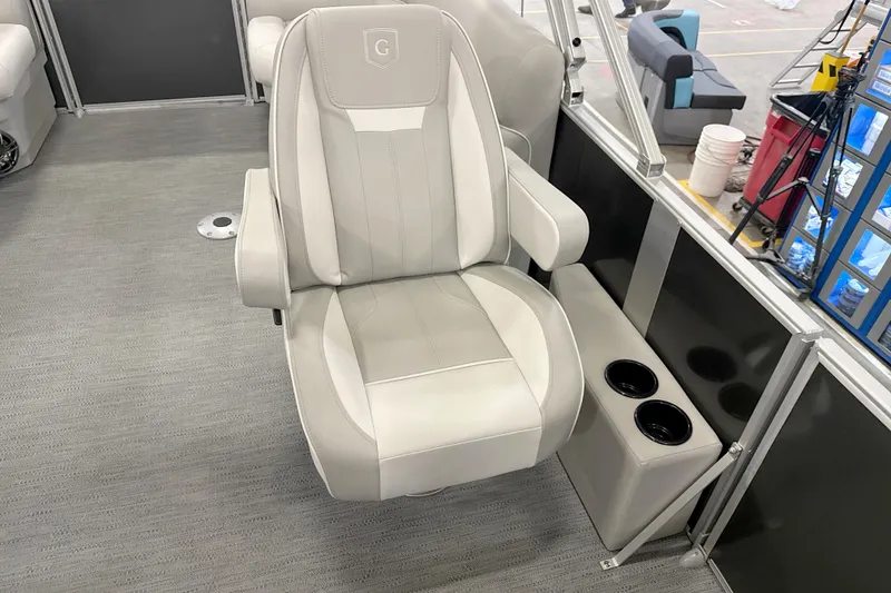 Slide: The Image of Luxurious captain's chair in 2026 Godfrey EX 2286 SBX pontoon boat, featuring dual cup holders. - 9