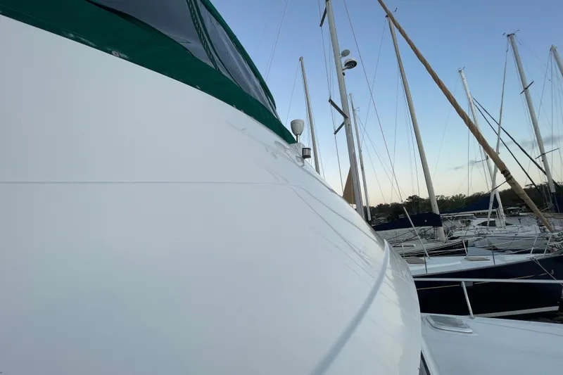 Slide: The Image of 2003 Mainship 430 Trawler docked at marina with sailboats in background. - 11