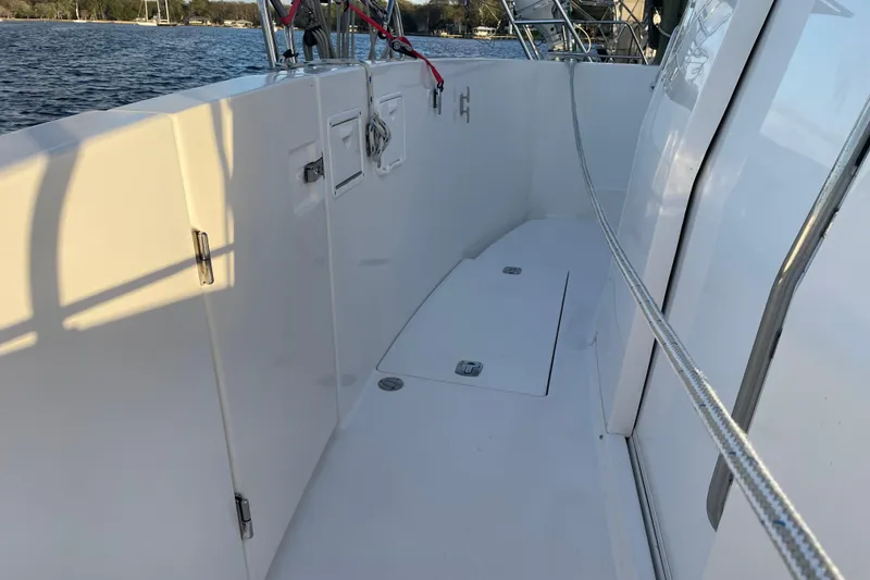 Slide: The Image of 2003 Mainship 430 Trawler deck with clean white surface and railing, near water. - 12