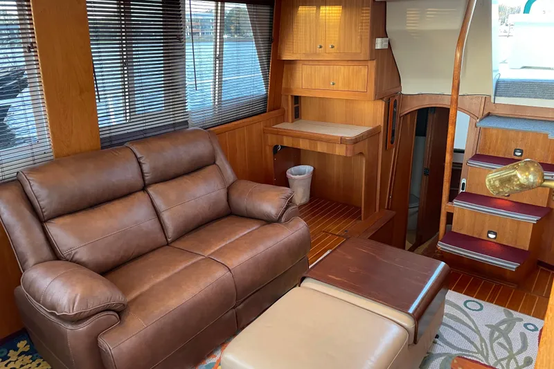 Slide: The Image of 2003 Mainship 430 Trawler interior with leather sofa, wooden cabinetry, and staircase. - 15