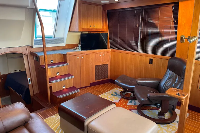 Slide: The Image of Luxurious interior of 2003 Mainship 430 Trawler with leather seating and wooden cabinetry. - 18
