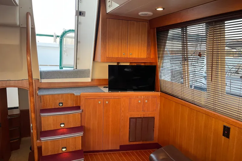 Slide: The Image of Interior of 2003 Mainship 430 Trawler with wooden cabinetry and a small TV. - 19