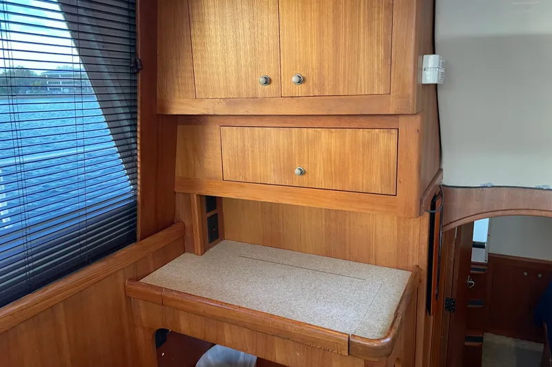 Slide: The Image of 2003 Mainship 430 Trawler interior with wooden cabinetry and window view. - 20