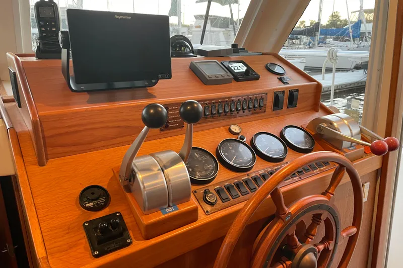 Slide: The Image of 2003 Mainship 430 Trawler helm with wooden wheel, gauges, and navigation equipment. - 22