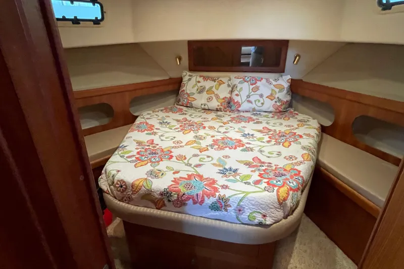 Slide: The Image of Cozy bedroom in 2003 Mainship 430 Trawler with floral bedding and wooden accents. - 33