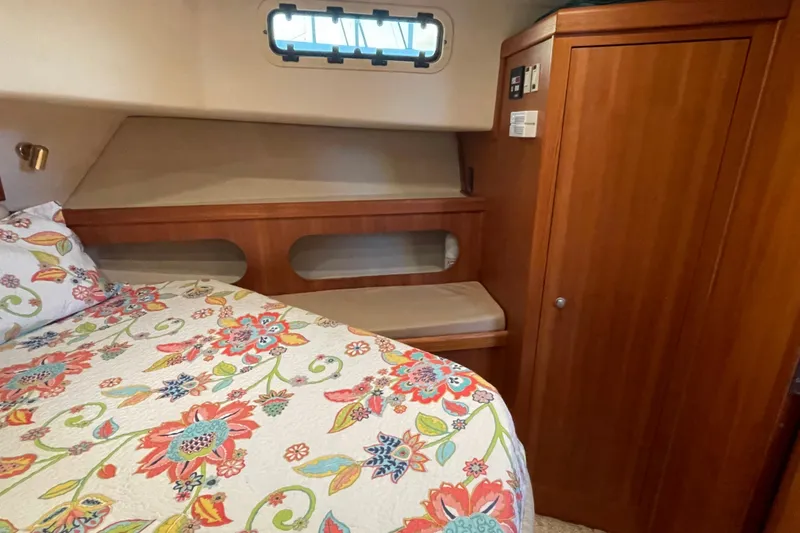 Slide: The Image of Cozy cabin interior of 2003 Mainship 430 Trawler with floral bedding and wooden cabinetry. - 35