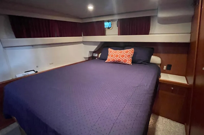 Slide: The Image of Cozy bedroom in 2003 Mainship 430 Trawler with purple bedding and decorative pillow. - 36