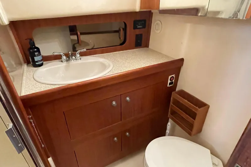 Slide: The Image of 2003 Mainship 430 Trawler bathroom with sink, mirror, and wooden cabinetry. - 39