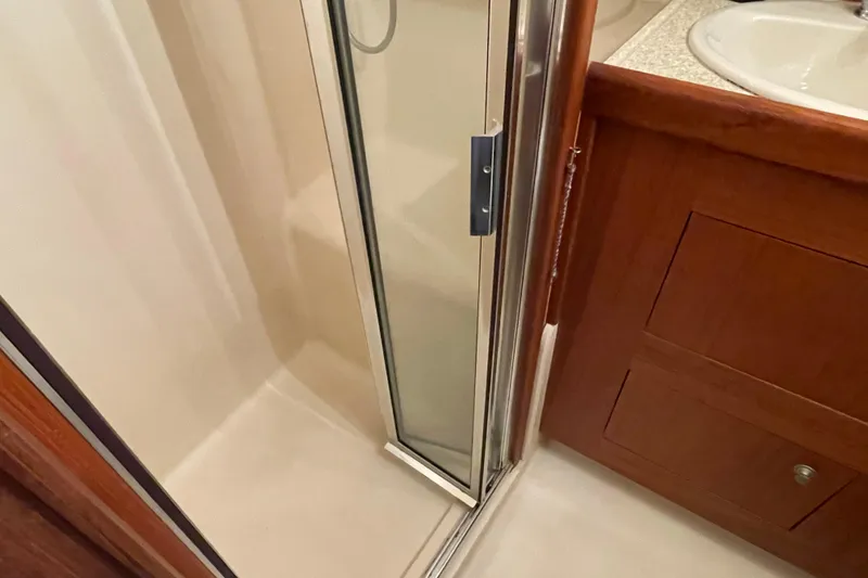 Slide: The Image of Shower area in 2003 Mainship 430 Trawler with wooden cabinetry and glass door. - 40