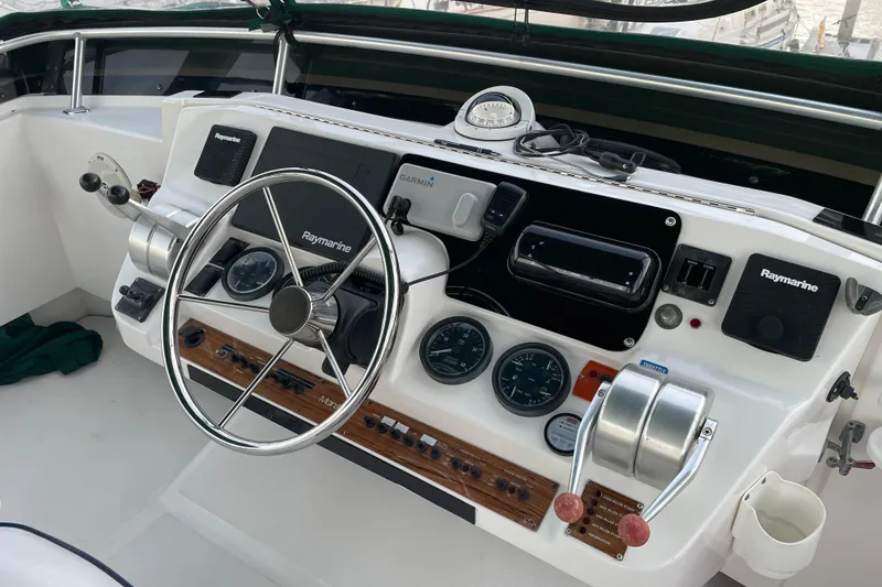 Slide: The Image of 2003 Mainship 430 Trawler helm with Raymarine electronics and steering wheel. - 46