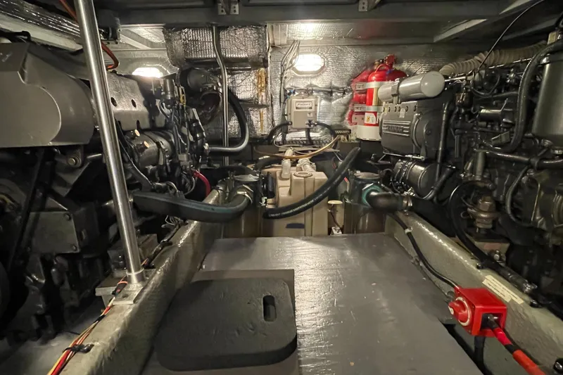 Slide: The Image of Engine room of 2003 Mainship 430 Trawler, featuring mechanical components and fire extinguisher. - 53