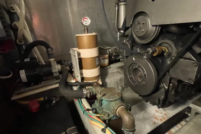 Slide: The Image of Engine room of 2003 Mainship 430 Trawler, showcasing mechanical components and piping. - 56