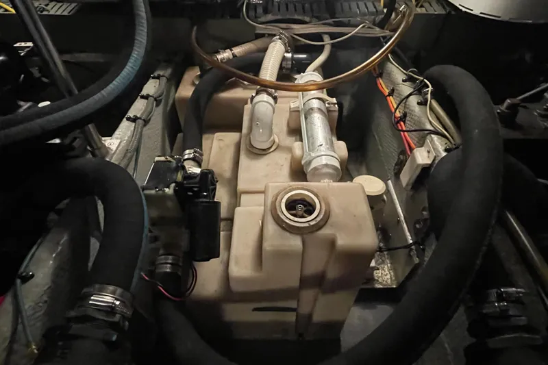 Slide: The Image of Engine compartment of a 2003 Mainship 430 Trawler, featuring hoses and components. - 58