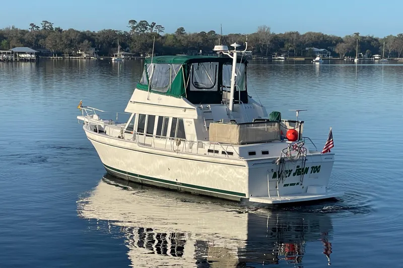Slide: The Image of 2003 Mainship 430 Trawler cruising on calm waters with scenic background. - 6