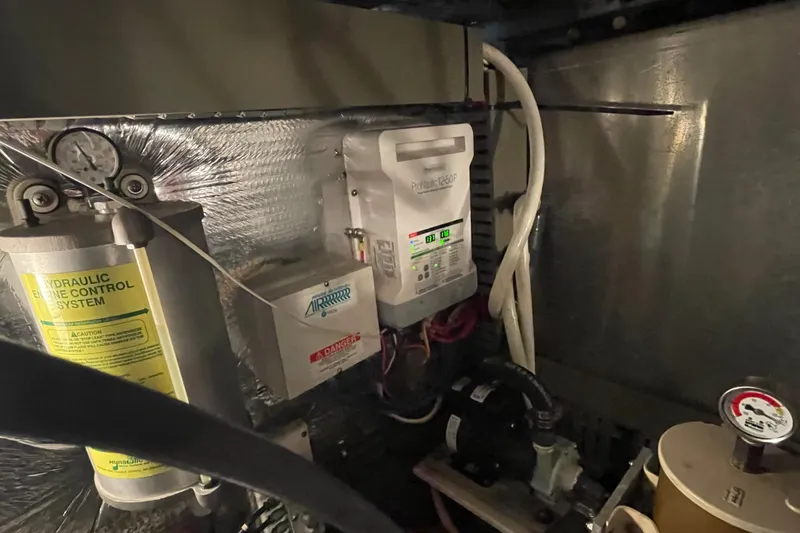 Slide: The Image of Engine room of 2003 Mainship 430 Trawler with hydraulic control system and electrical components. - 60