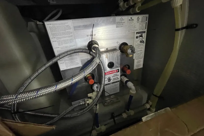 Slide: The Image of Electrical panel with warning labels and cables on a 2003 Mainship 430 Trawler. - 63