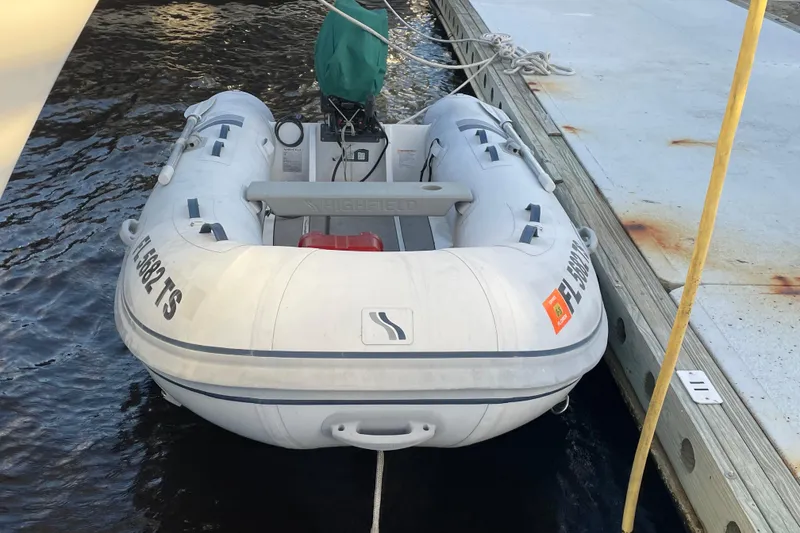 Slide: The Image of Inflatable dinghy docked beside a pier, associated with a 2003 Mainship 430 Trawler. - 64