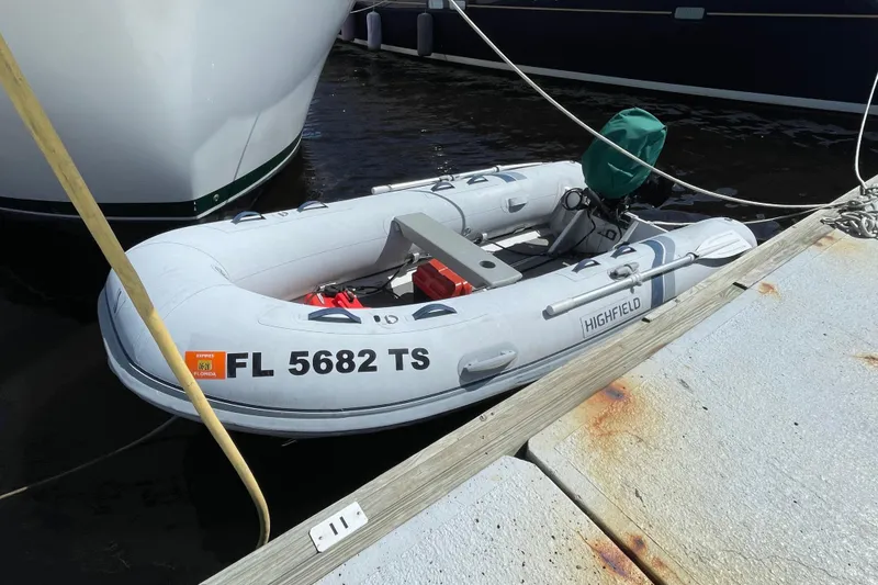 Slide: The Image of Inflatable dinghy docked beside a Mainship 430 Trawler, 2003 model, with Florida registration. - 65