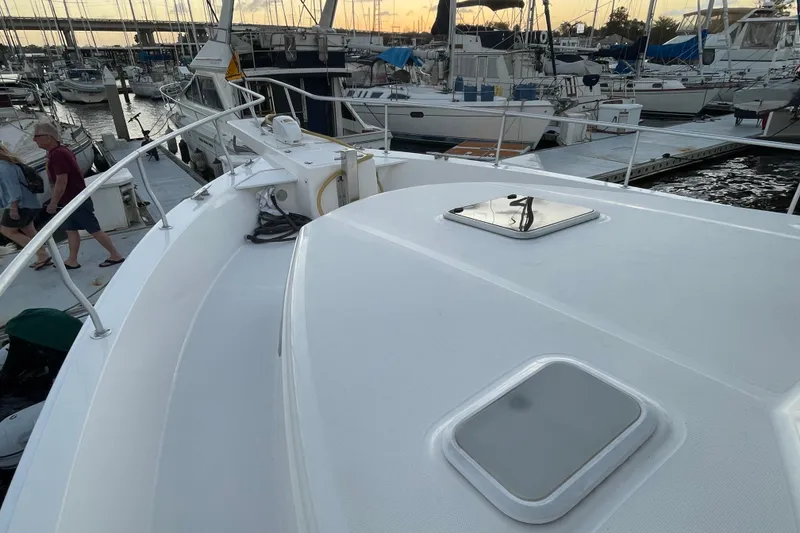Slide: The Image of 2003 Mainship 430 Trawler docked at marina during sunset, with visible deck and hatches. - 8
