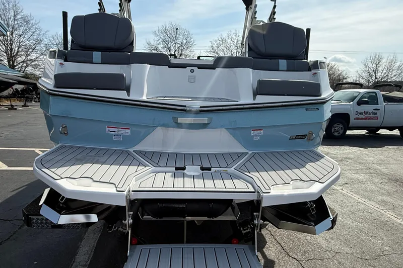 Slide: The Image of 2026 MasterCraft XT24 boat with sleek design and spacious seating, parked outdoors. - 2