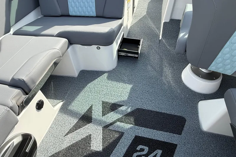 Slide: The Image of Interior of 2026 MasterCraft XT24 boat with gray seating and logo on carpet. - 6