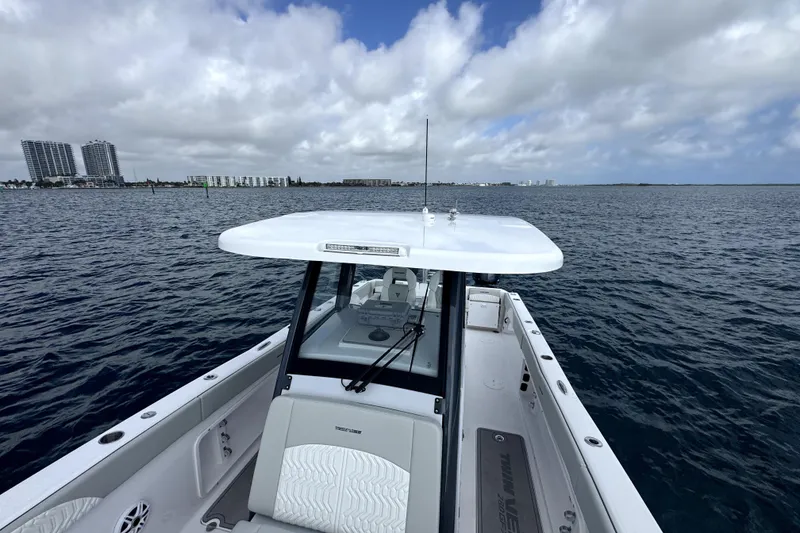 Slide: The Image of 2026 Twin Vee 280 GFX2 CC boat on open water with city skyline in background. - 14