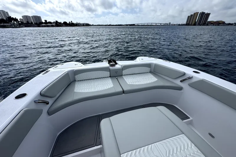Slide: The Image of 2026 Twin Vee 280 GFX2 CC boat interior with cushioned seating on calm water. - 16