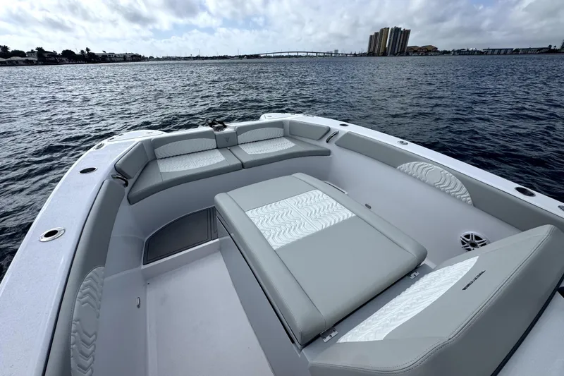 Slide: The Image of 2026 Twin Vee 280 GFX2 CC boat interior with cushioned seating on calm water. - 17
