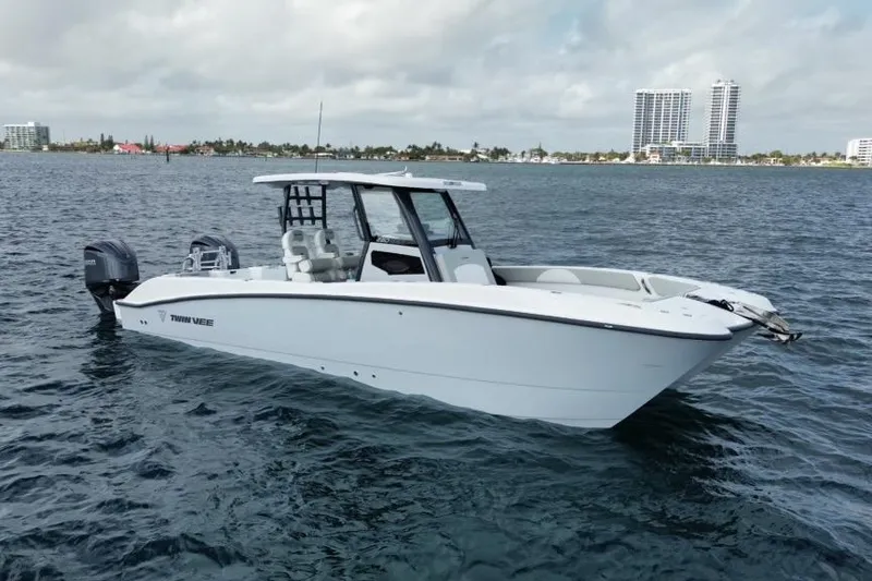 Slide: The Image of 2026 Twin Vee 280 GFX2 CC boat on calm water, cityscape in background. - 3