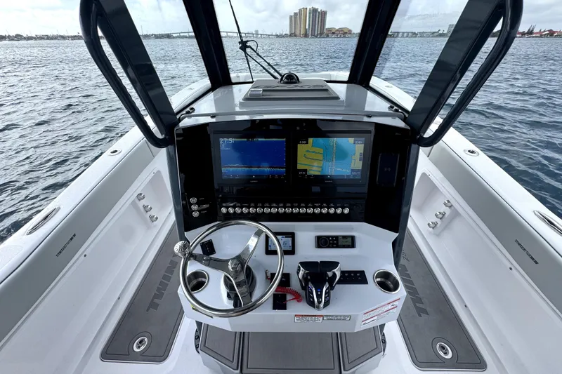 Slide: The Image of 2026 Twin Vee 280 GFX2 CC boat helm with advanced navigation displays on open water. - 7