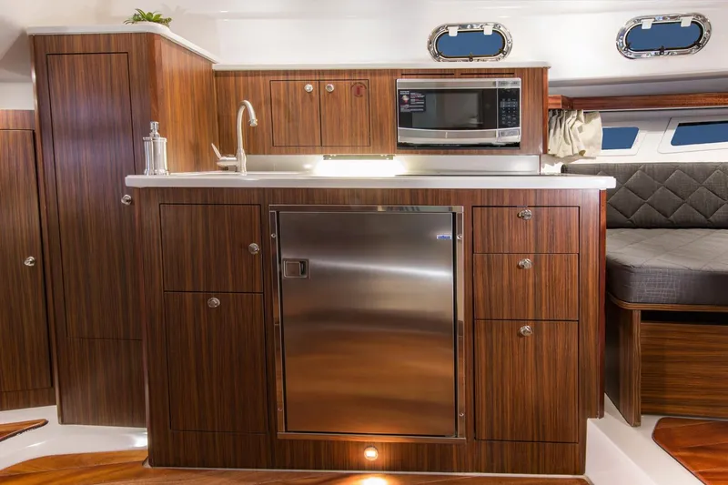 Slide: The Image of Manufacturer Provided Image: 2016 Pursuit OS 355 Offshore yacht kitchen with wood cabinetry and stainless steel appliances. - 8