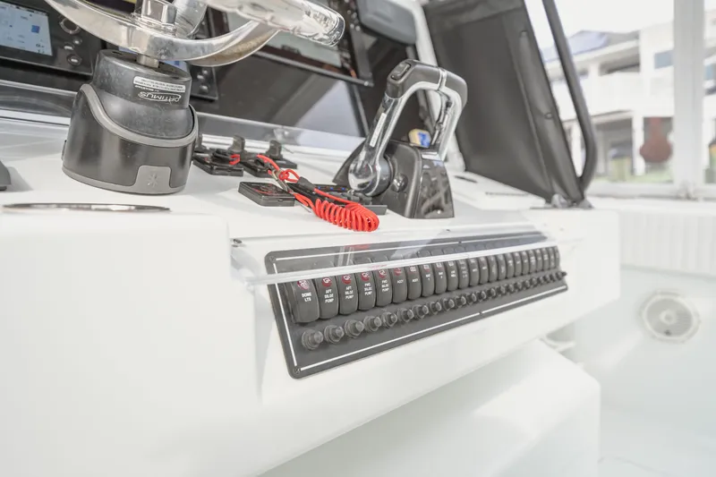 Slide: The Image of Control panel of a 2018 Freeman 37 VH boat, featuring switches and steering. - 20
