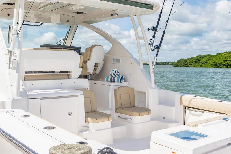Slide: The Image of Manufacturer Provided Image: 2016 Pursuit OS 355 Offshore boat interior with seating and fishing rods. - 4