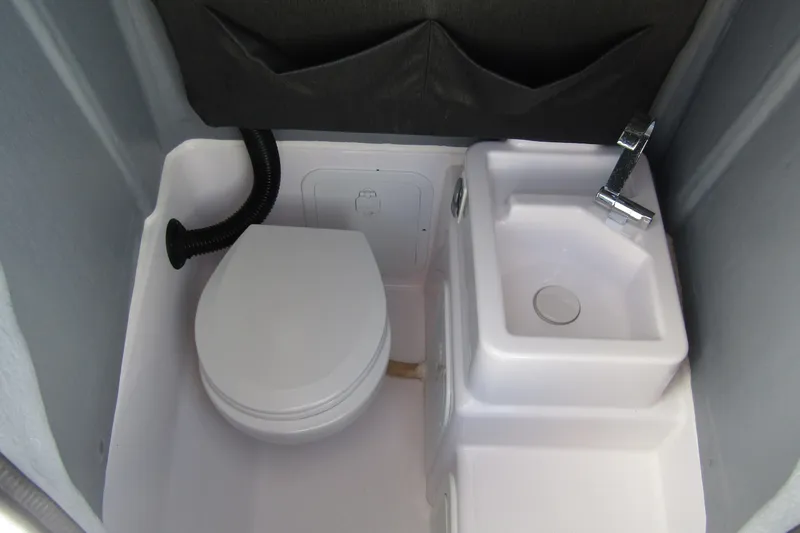 Slide: The Image of 2022 Axopar 22 T-Top boat interior with compact toilet and sink. - 10