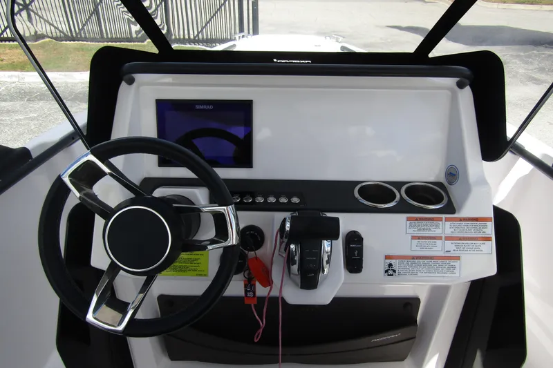 Slide: The Image of 2022 Axopar 22 T-Top boat dashboard with steering wheel and control panel. - 12