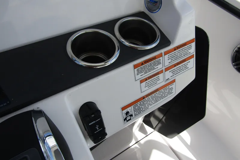 Slide: The Image of 2022 Axopar 22 T-Top boat console with cup holders and warning labels. - 17
