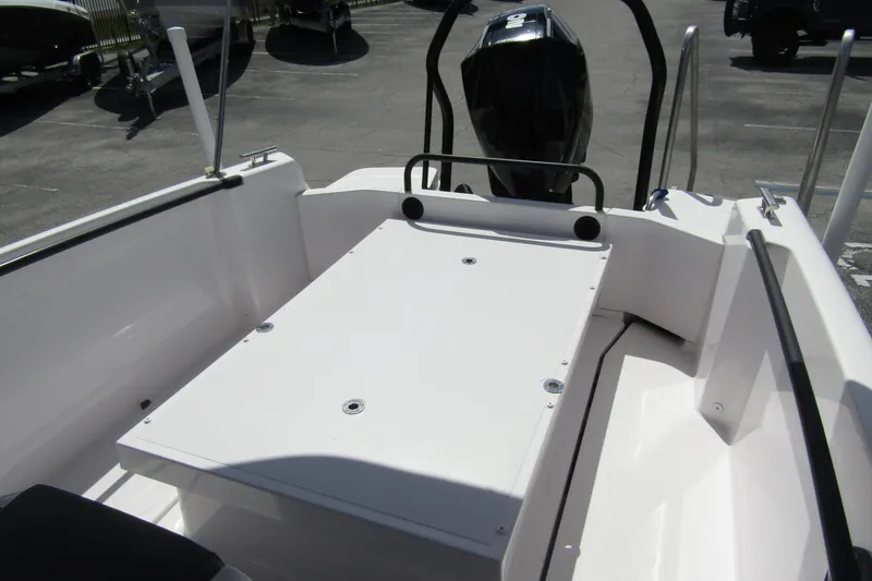 Slide: The Image of 2022 Axopar 22 T-Top boat interior with seating and engine view. - 19