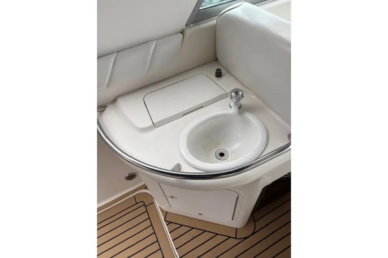Slide: The Image of 1998 Sea Ray Sundancer 330 boat sink with white countertop and wooden flooring. - 14
