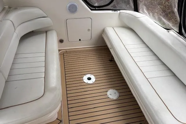 Slide: The Image of 1998 Sea Ray Sundancer 330 interior with white seating and wood-patterned flooring. - 16