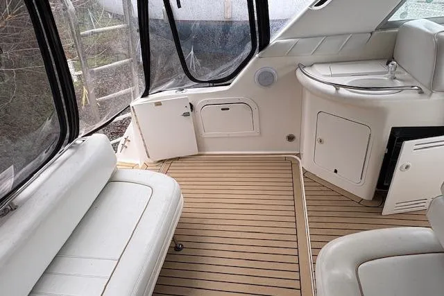 Slide: The Image of 1998 Sea Ray Sundancer 330 interior with white seating and wood-style flooring. - 26